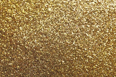 Beautiful shiny golden glitter as background, closeup