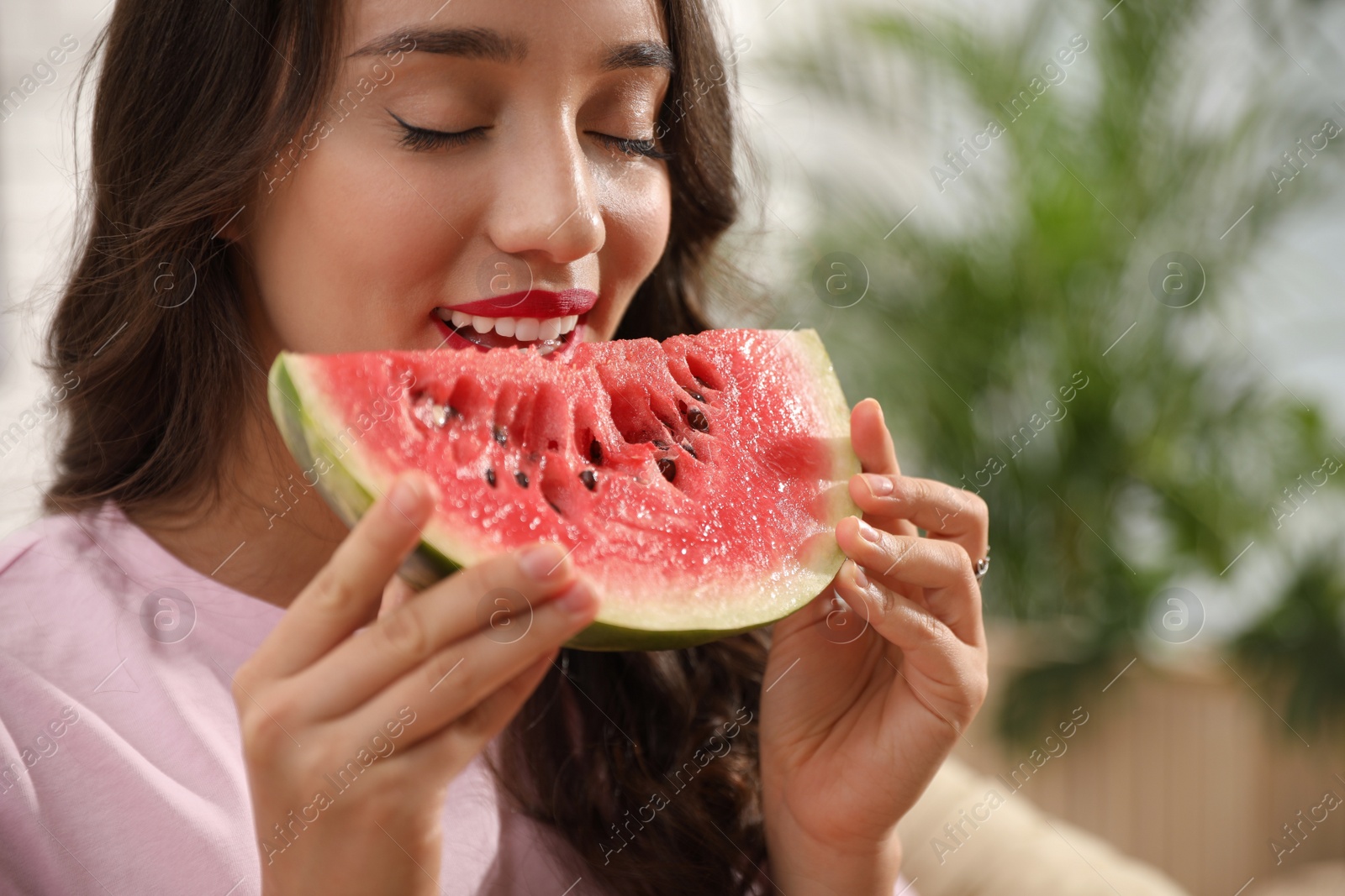 Photo of Beautiful young woman with watermelon at home, closeup