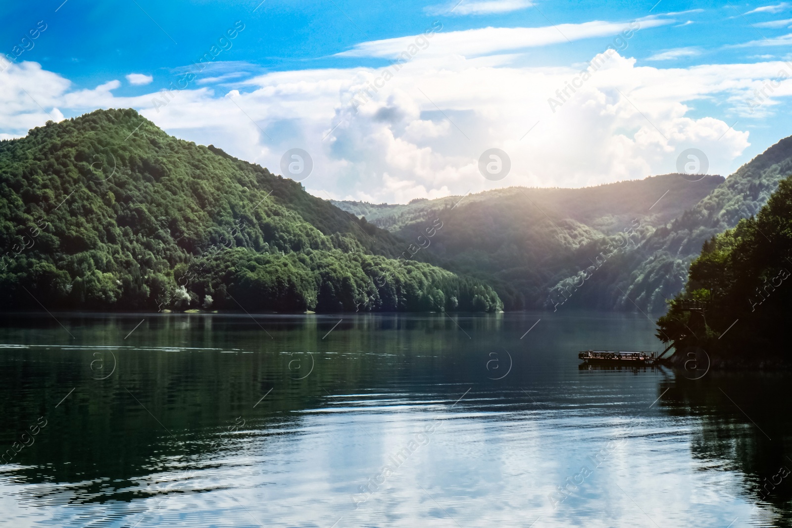 Photo of Picturesque view of beautiful lake surrounded by mountains on sunny day