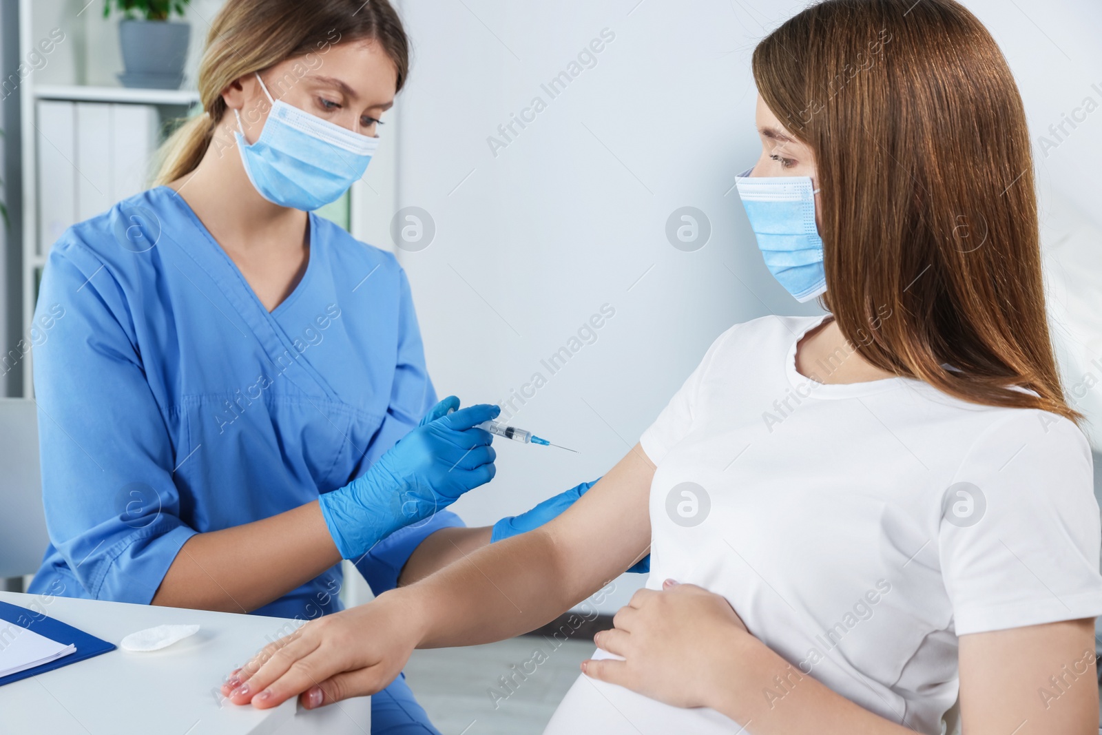 Photo of Doctor giving injection to pregnant woman in hospital