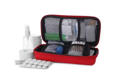 Photo of Red first aid kit with cotton buds, pins, pills, hand sanitizer and elastic bandage isolated on white