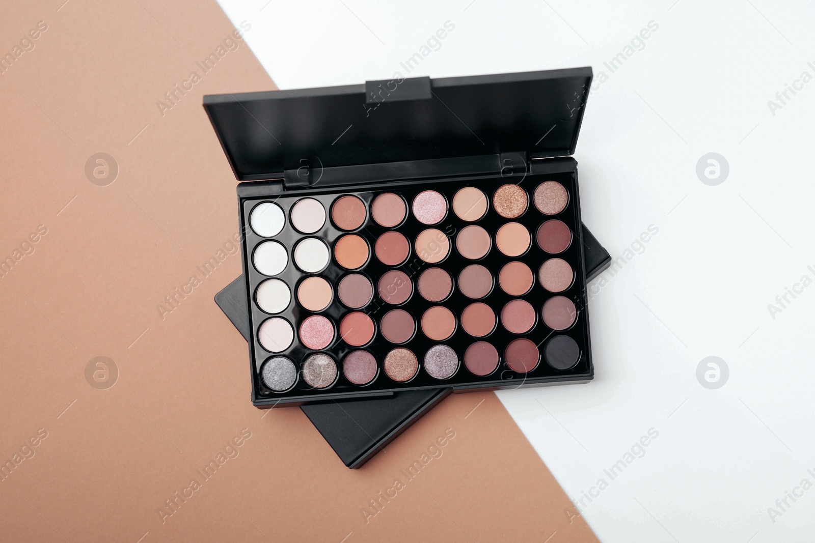 Photo of Eye shadow palette on colorful background, top view