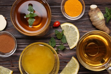 Photo of Flat lay composition of tea with honey and ingredients on wooden table