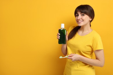 Photo of Young woman with mouthwash and toothbrush on yellow background, space for text