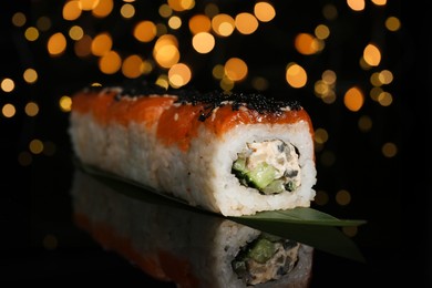 Photo of Delicious sushi rolls with salmon on table against blurred lights