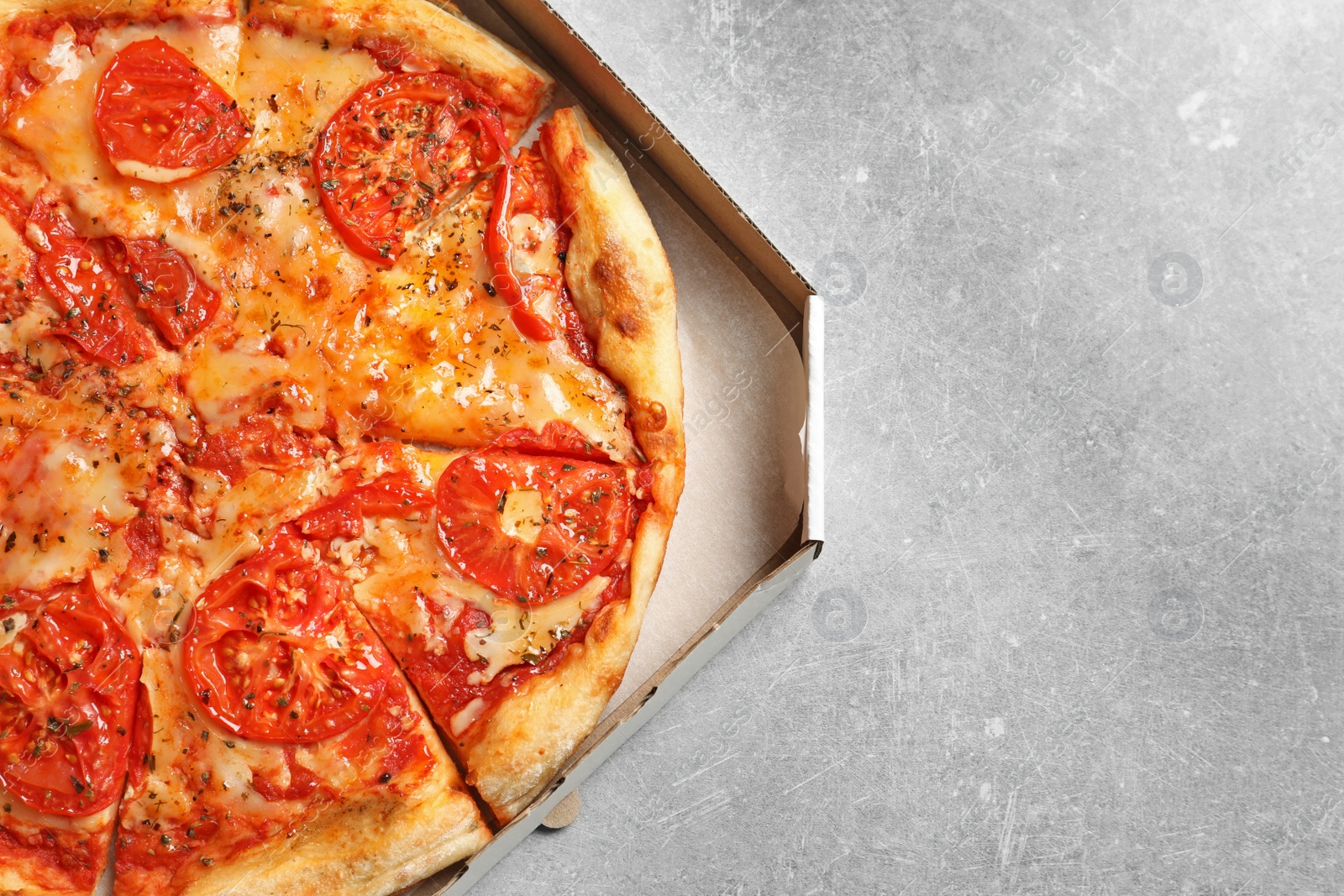 Photo of Cheese pizza in carton box on grey background, top view with space for text. Food delivery service