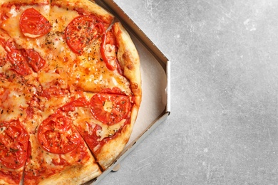 Photo of Cheese pizza in carton box on grey background, top view with space for text. Food delivery service