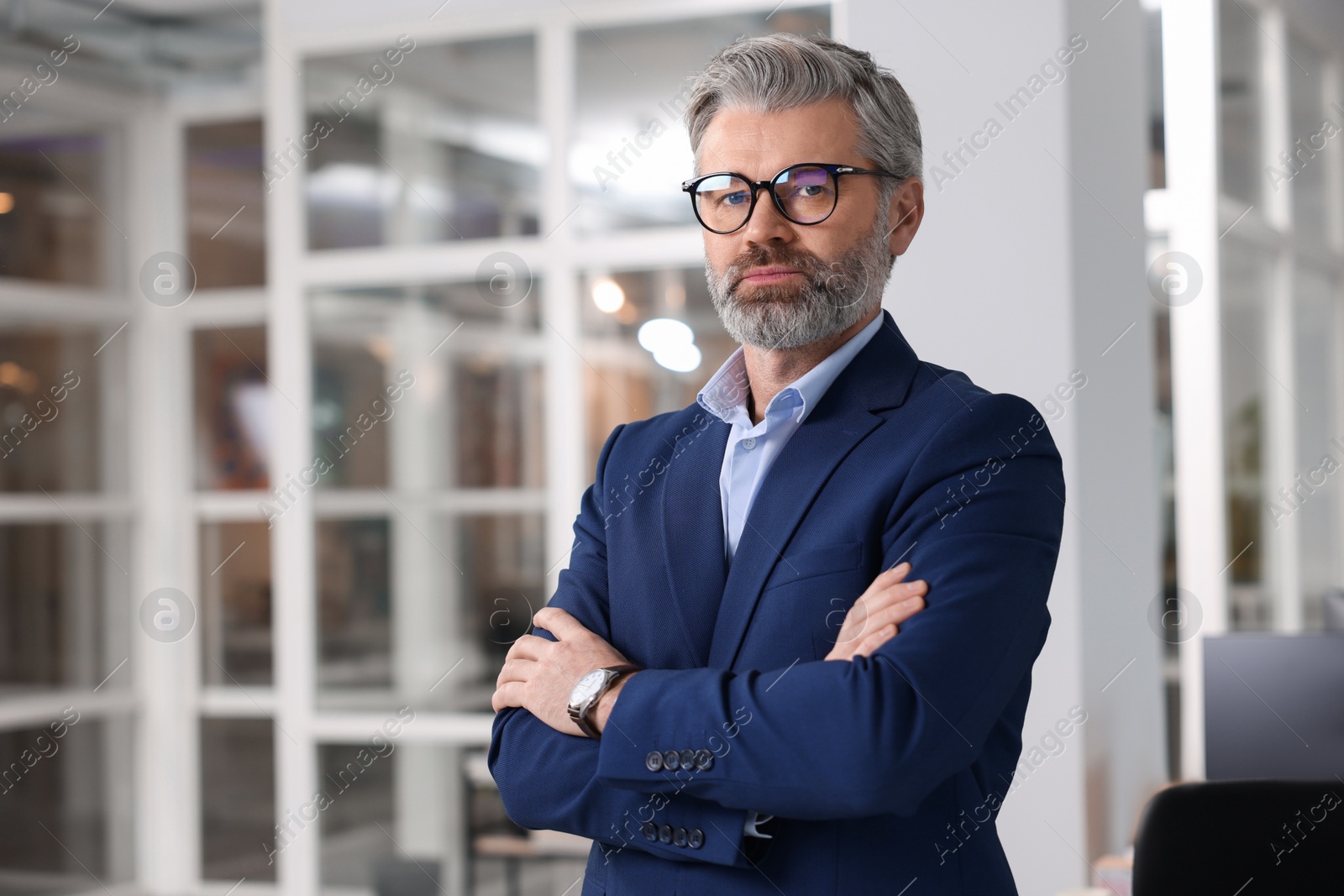 Photo of Portrait of handsome man with crossed arms in office, space for text. Lawyer, businessman, accountant or manager