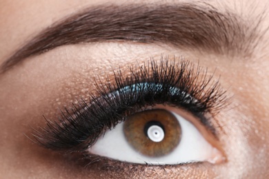 Photo of Young woman with eyelash extensions and beautiful makeup, closeup view