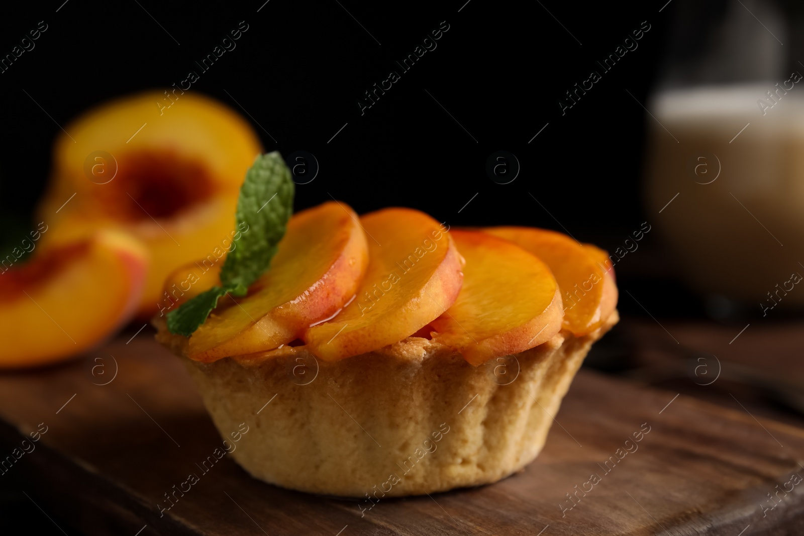 Photo of Delicious peach dessert on wooden board, closeup