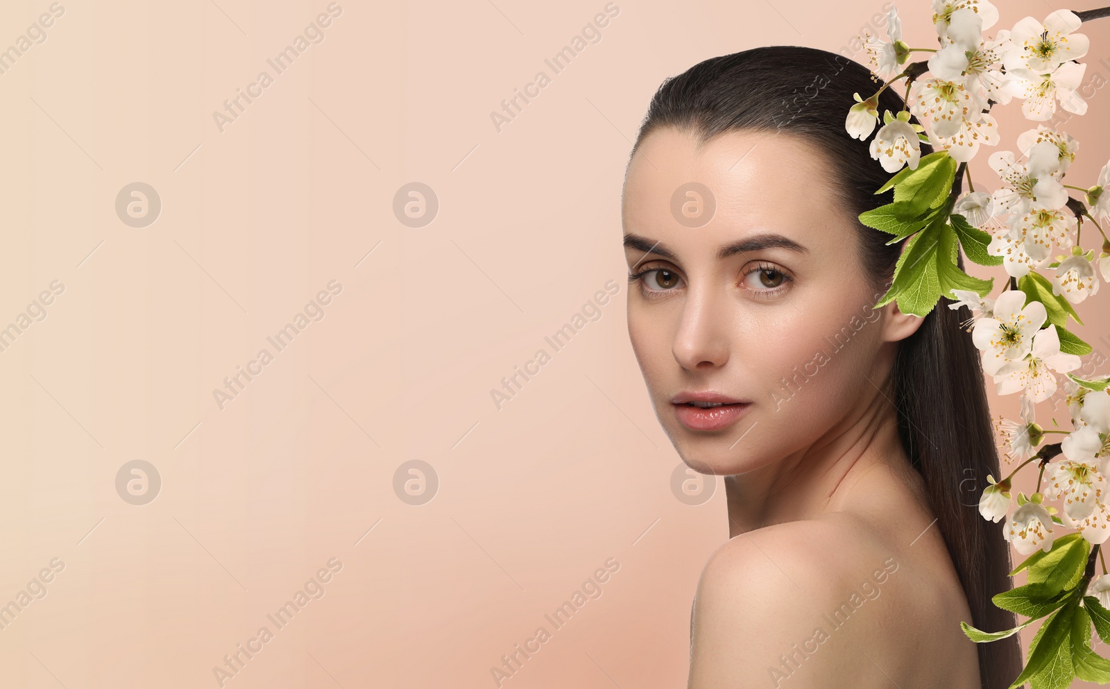 Image of Beautiful woman with smooth skin and flowers on beige background. Space for text