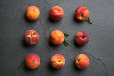 Photo of Fresh sweet peaches on black table, flat lay
