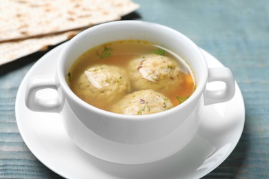 Photo of Bowl of Jewish matzoh balls soup on color wooden table