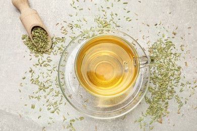 Aromatic fennel tea and seeds on light grey table, flat lay