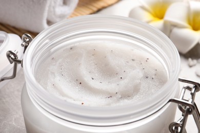 Photo of Body scrub in glass jar on table, closeup