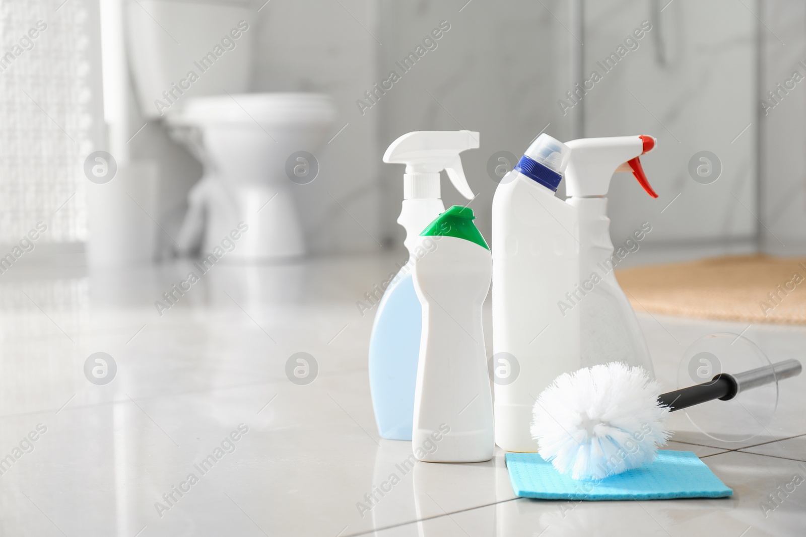 Photo of Cleaning supplies and toilet bowl in bathroom. Space for text