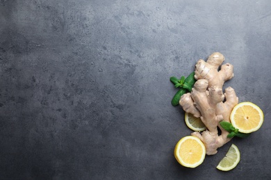 Photo of Fresh lemon, ginger and mint on grey table, flat lay. Space for text