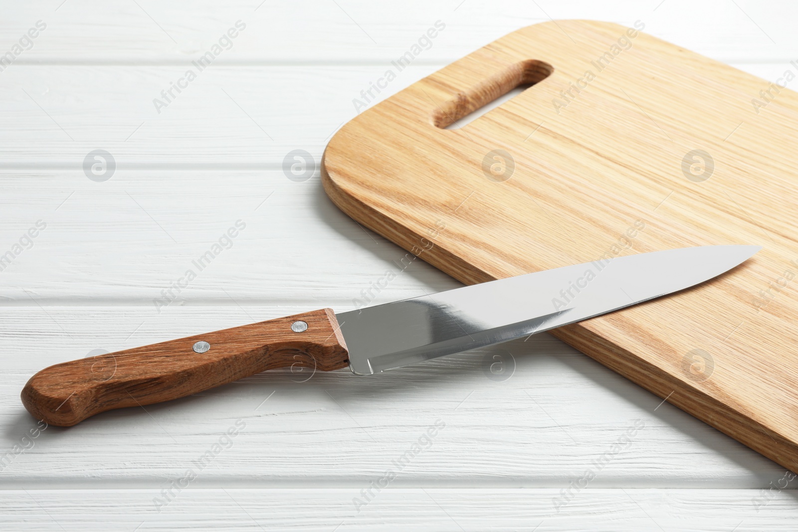 Photo of One sharp knife on white wooden table, closeup