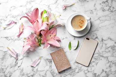 Photo of Flat lay composition with lily flowers, cup of coffee and smartphone on marble background