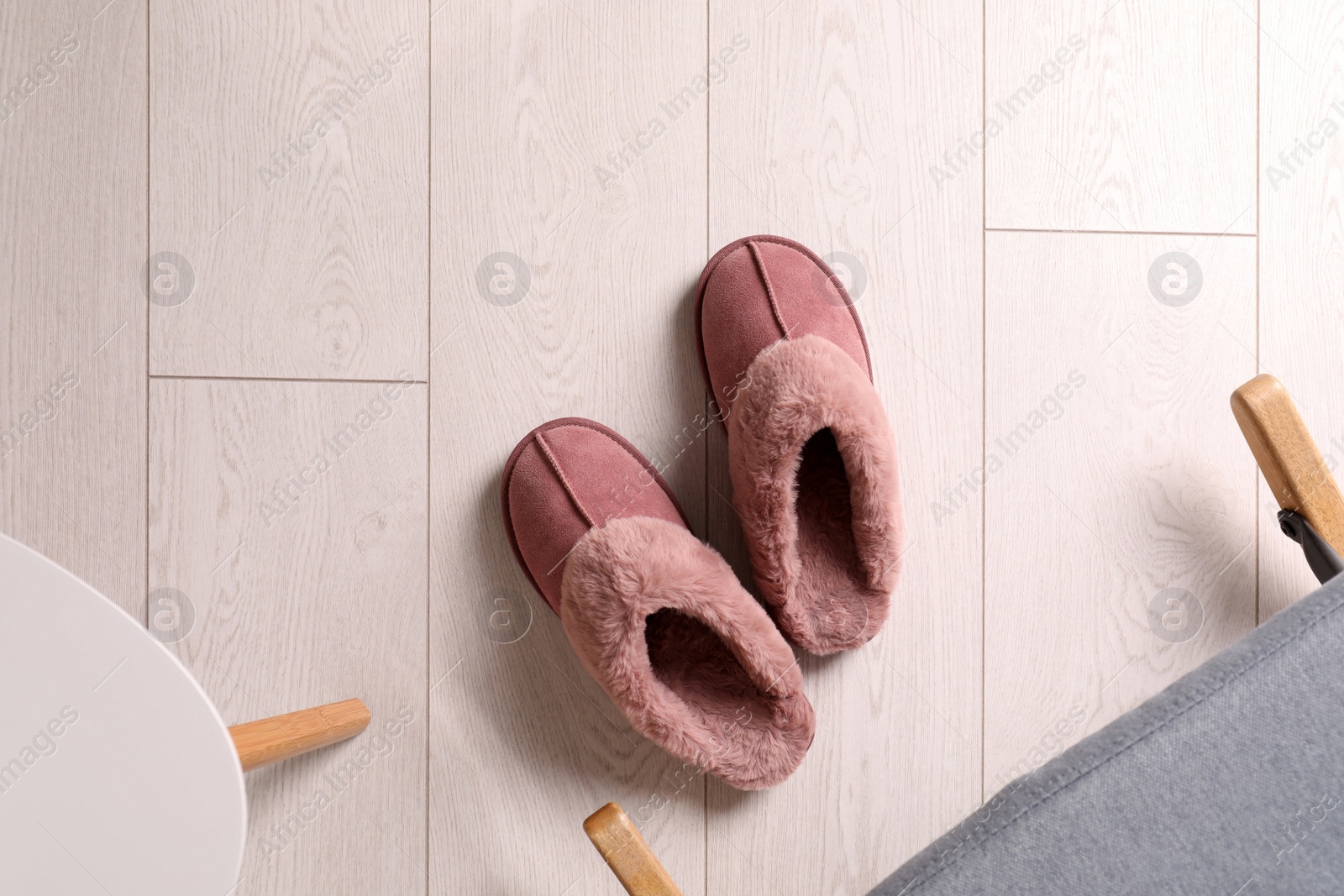 Photo of Pink warm slippers on floor indoors, flat lay