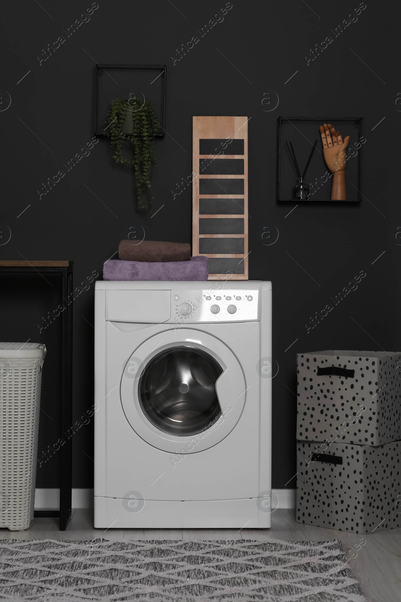 Photo of Stylish laundry room with washing machine. Interior design