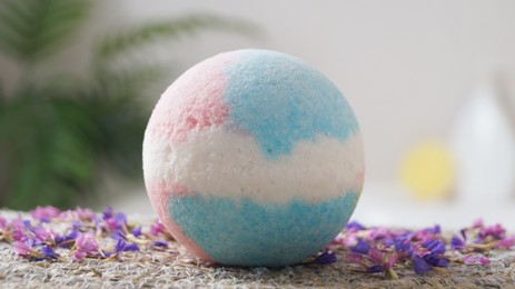 Photo of Beautiful bath bomb on wicker mat indoors, closeup