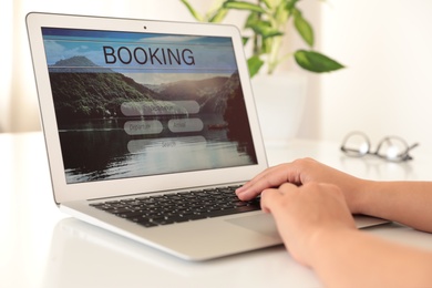 Woman booking tickets online indoors, closeup. Travel agency concept