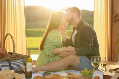 Photo of Romantic date. Beautiful couple kissing during picnic on sunny day