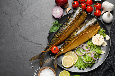 Photo of Flat lay composition with tasty smoked fish on dark table