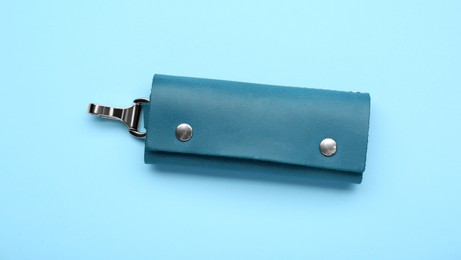 Photo of Stylish leather keys holder on light blue background, top view