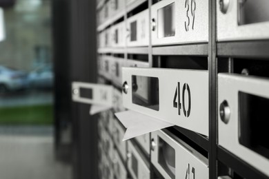 Photo of Open mailboxes with keyholes, numbers and receipts in post office, closeup