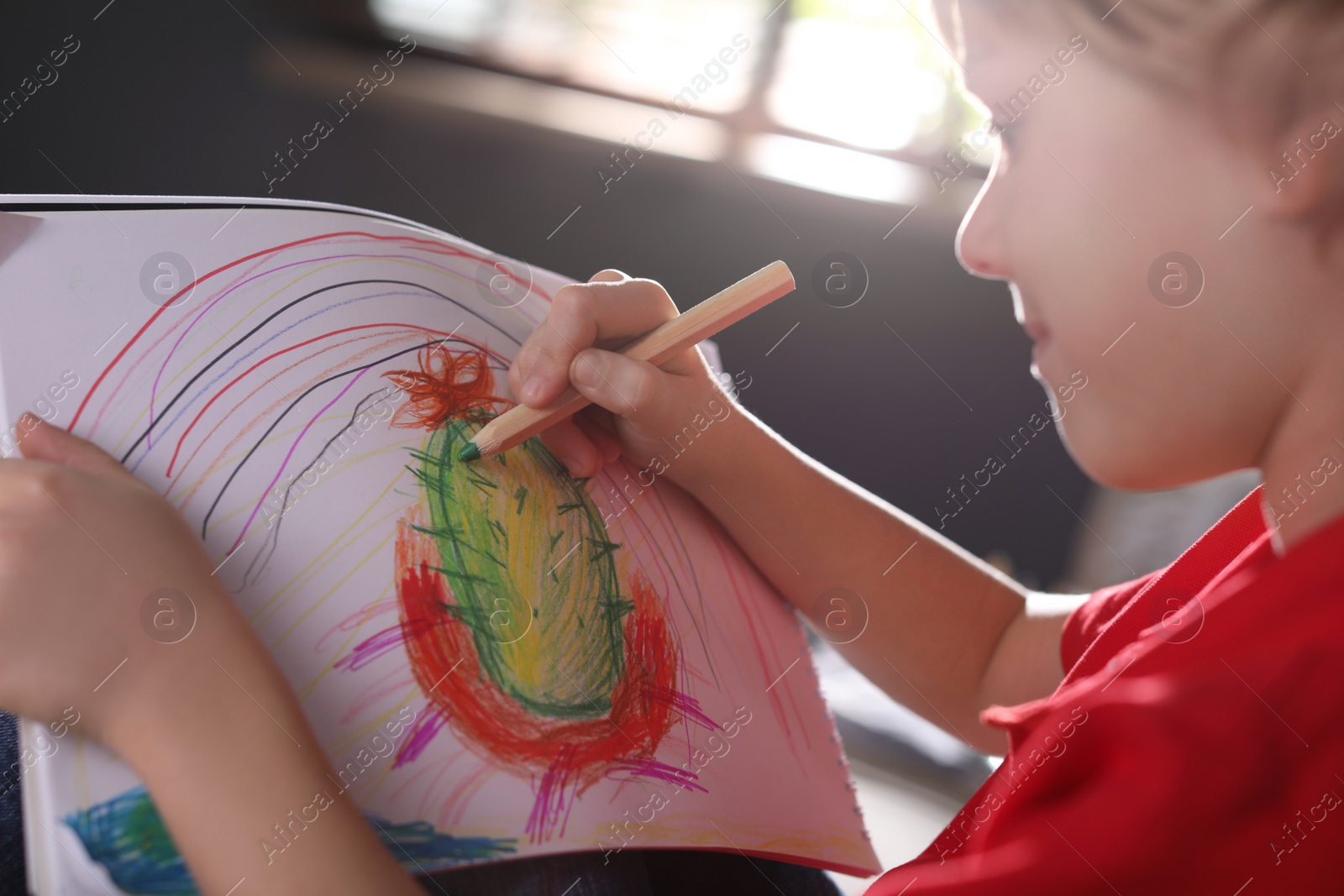 Photo of Little boy drawing at home, closeup. Creative hobby