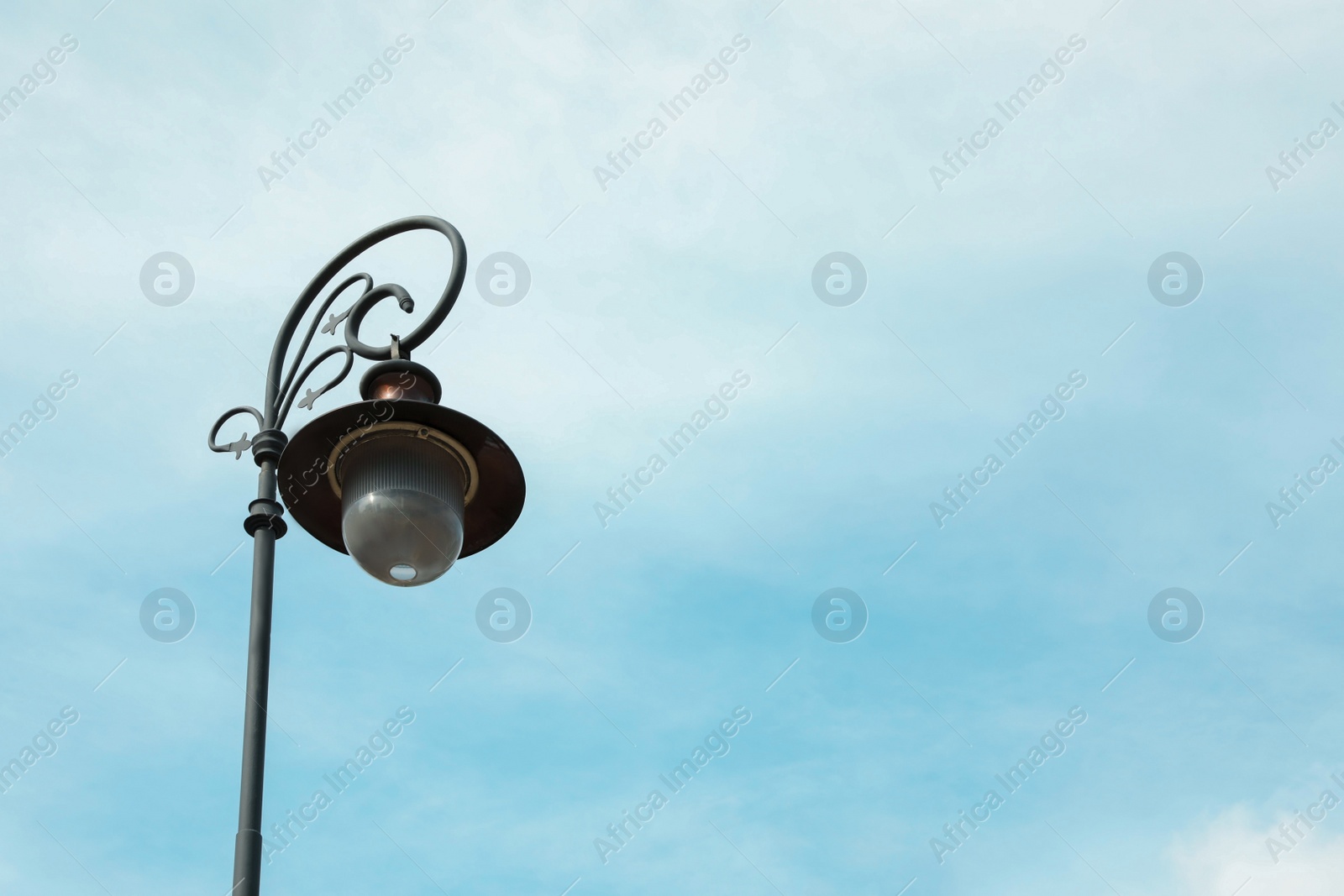 Photo of Old fashioned street light lamp against cloudy sky