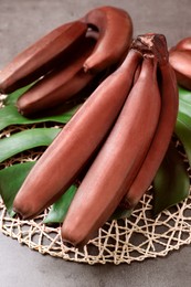 Photo of Tasty red baby bananas on grey table