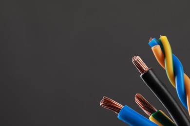 Photo of New colorful electrical wires on gray background, space for text