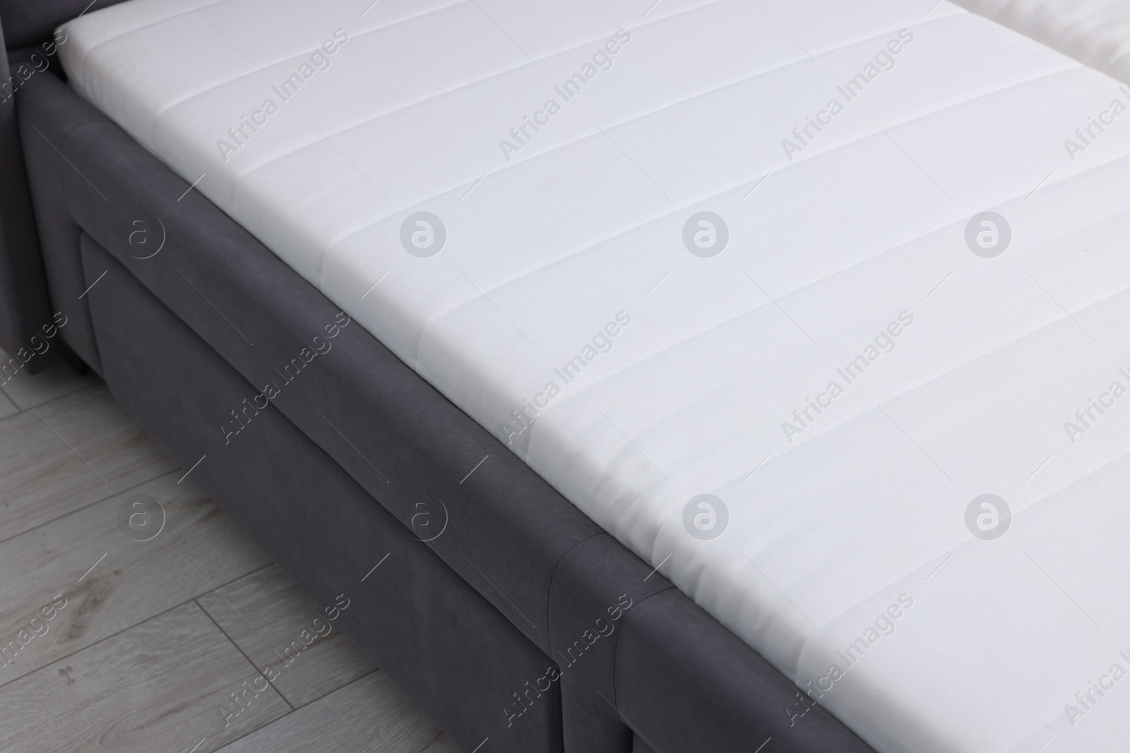 Photo of Comfortable bed with new soft mattress indoors