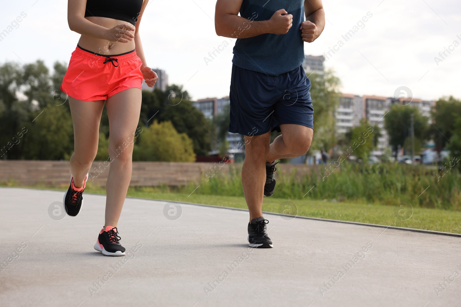 Photo of Healthy lifestyle. Couple running outdoors, closeup view