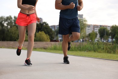 Photo of Healthy lifestyle. Couple running outdoors, closeup view