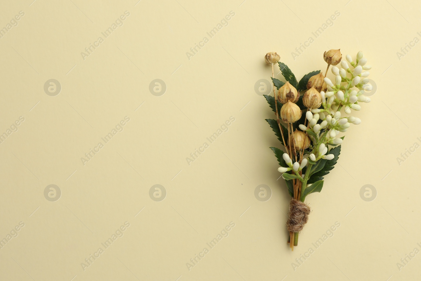 Photo of Small stylish boutonniere on beige background, top view. Space for text