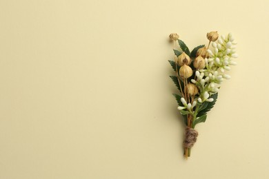 Photo of Small stylish boutonniere on beige background, top view. Space for text
