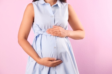 Photo of Pregnant woman posing on color background, closeup