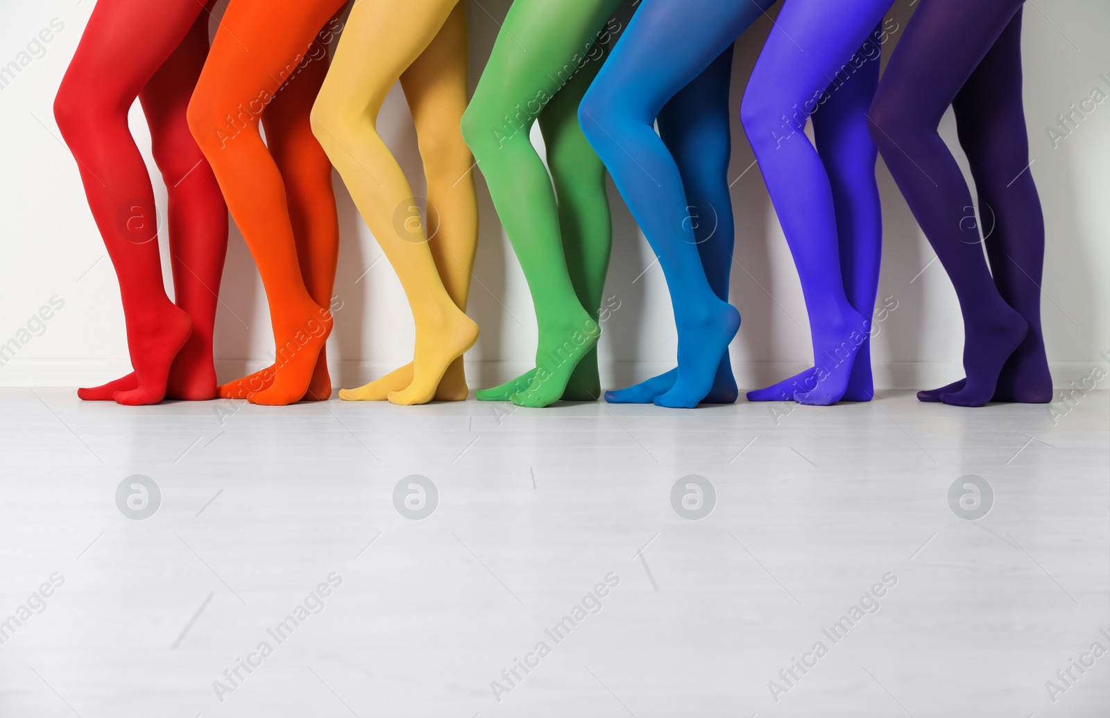 Photo of Women wearing colorful tights near white wall, closeup