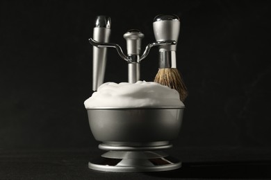Photo of Set of men's shaving tools and foam on black background