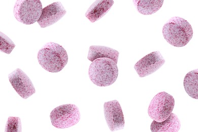 Vitamin. Pink tablets falling on white background