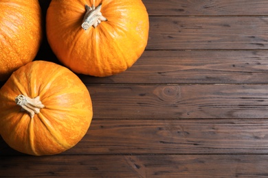 Flat lay composition with pumpkins and space for text on wooden background. Autumn holidays