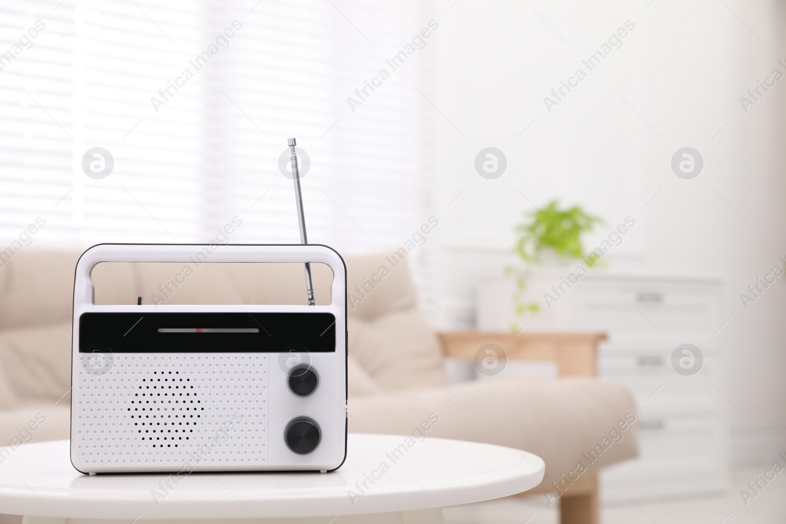 Photo of Stylish white radio on table indoors. Space for text