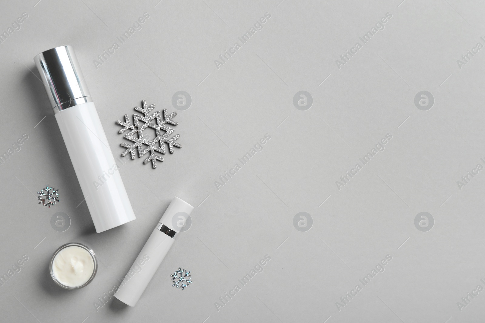 Photo of Flat lay composition with different cosmetic products on light grey background, space for text. Winter care
