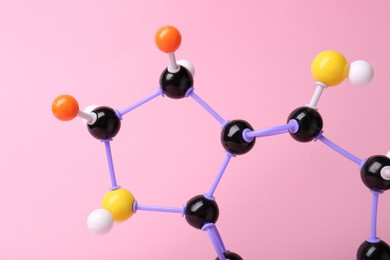 Photo of Structure of molecule on pink background, closeup. Chemical model