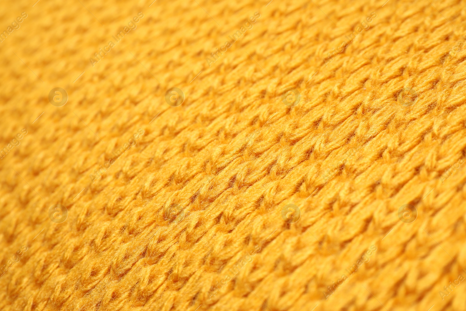 Photo of Texture of yellow knitted blanket as background, closeup