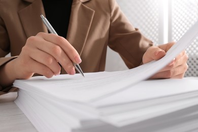 Photo of Woman signing document at table, closeup view